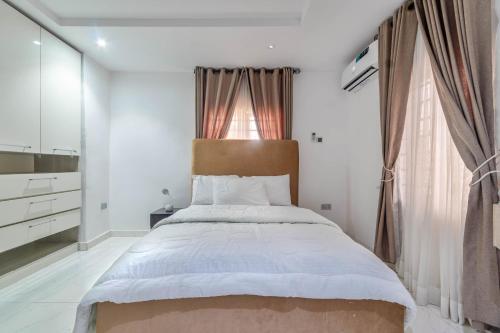 a bedroom with a large bed and a window at Gorgeous Short-let Apartment Lekki in Lekki