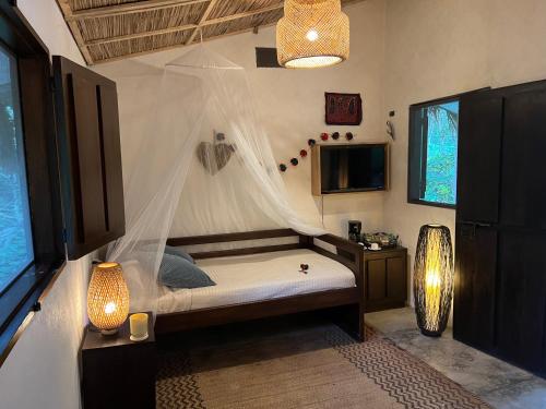 a bedroom with a bed with a mosquito net at Reserva Natural Tierra Adentro in Minca