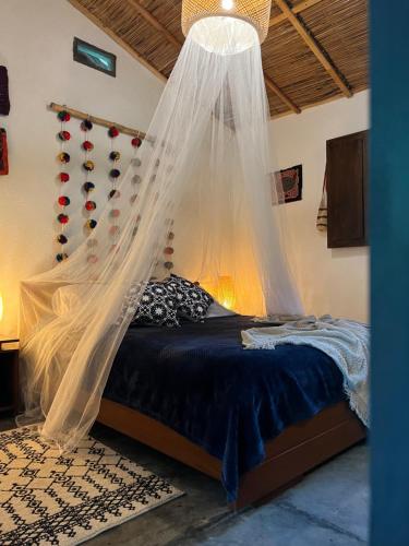 a bedroom with a bed with a mosquito net at Reserva Natural Tierra Adentro in Minca