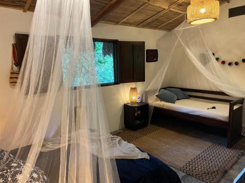a bedroom with a bed with a mosquito net at Reserva Natural Tierra Adentro in Minca