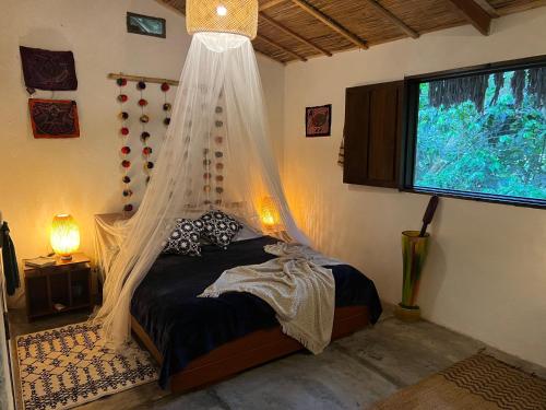 a bedroom with a bed with a mosquito net at Reserva Natural Tierra Adentro in Minca