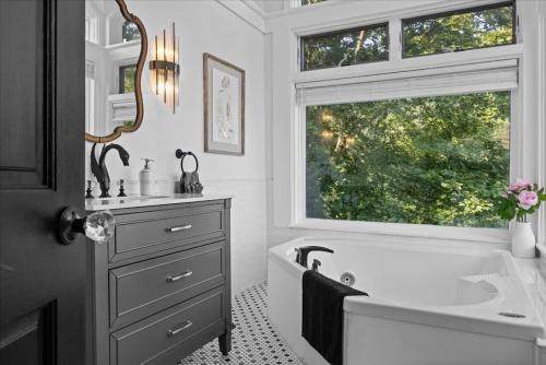 a bathroom with a tub and a sink and a window at Stunning views from stylish 3-bedroom home in Pittsburgh