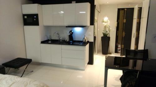 a kitchen with white cabinets and a sink in a room at Eider in Cannes