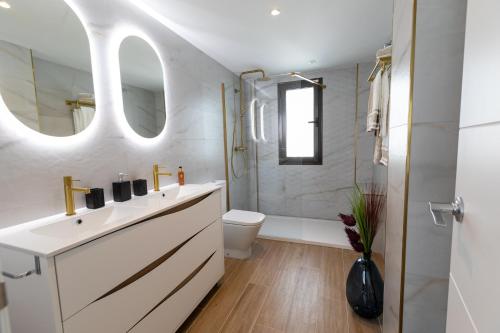 łazienka z umywalką, toaletą i lustrem w obiekcie Penthouse in Estepona - Malaga w mieście Estepona