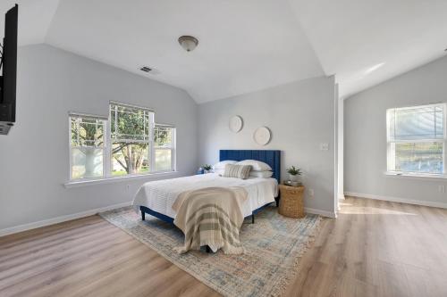 アトランタにあるZen Home in the Heart of Atlantaの白いベッドルーム(ベッド1台、窓2つ付)