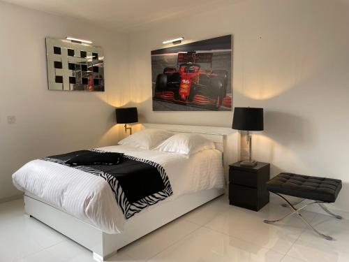 una camera con un letto e una foto di una macchina da corsa di Eider a Cannes
