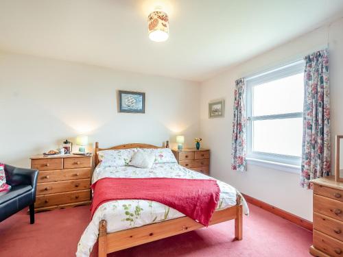 a bedroom with a bed and a window at Jura in Drummore