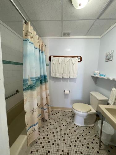 a bathroom with a toilet and a shower curtain at Barcelona Motel in Wildwood Crest