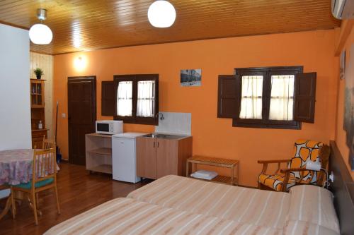 a bedroom with two beds and a kitchen with a microwave at Habitación independiente en Casa Rural Javier in Valmuel