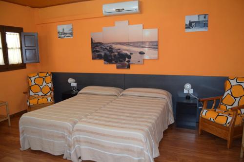 1 cama en un dormitorio con pared de color naranja en Habitación independiente en Casa Rural Javier, en Valmuel