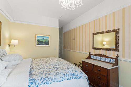 a bedroom with a bed and a dresser and a mirror at Golden Gate Hotel in San Francisco