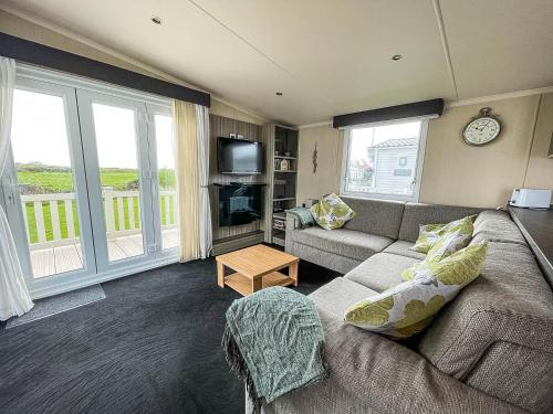 a living room with a couch and a tv at Modern 6 Berth Caravan At Martello Beach In Essex Ref 29002sv in Clacton-on-Sea