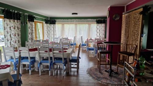 a dining room with white tables and blue chairs at Rezydencja Nad Potoczkiem in Wisła