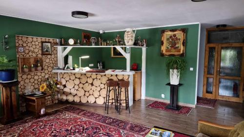 una sala de estar con paredes verdes y un bar con mesa. en Rezydencja Nad Potoczkiem, en Wisła