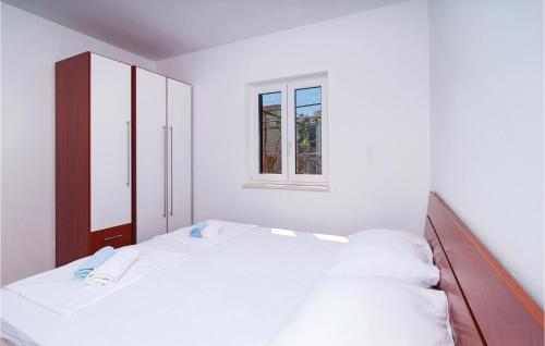 a white bedroom with two beds and a window at Nice Apartment In Sutivan With Wifi in Sutivan