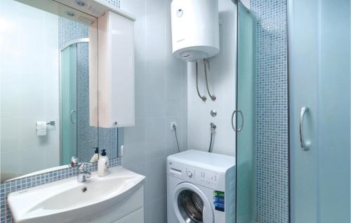 a bathroom with a washing machine and a sink at Nice Apartment In Sutivan With Wifi in Sutivan