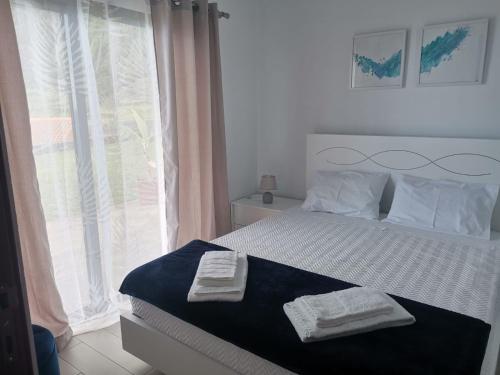 een slaapkamer met een bed met twee handdoeken erop bij Oceanus in Faja Grande