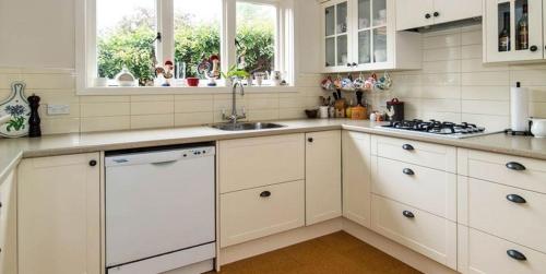 a kitchen with white cabinets and a sink at Seaview Sefton in Timaru