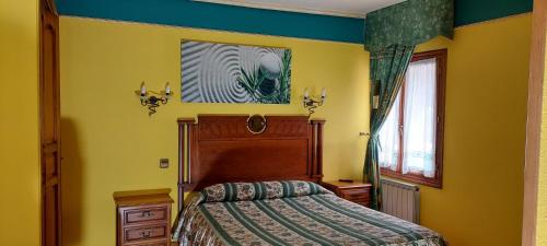 1 dormitorio con 1 cama y una pintura en la pared en Hotel Rural Bereau, en Lesaka