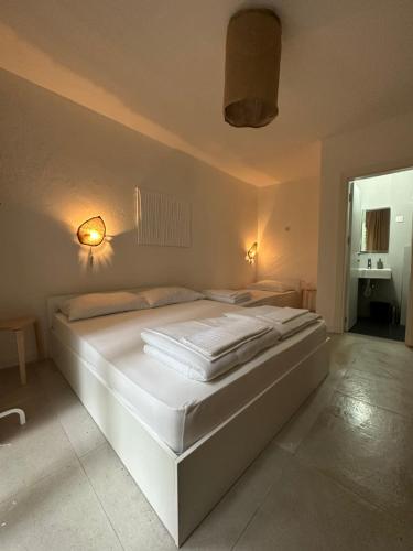 a white bed in a room with two lamps at Villa Vele in Herceg-Novi