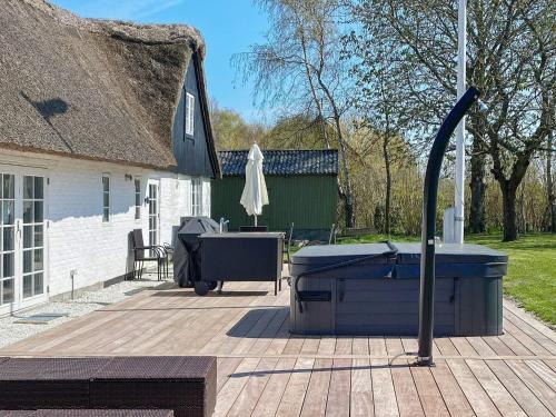 een hot tub en een grill op een patio bij 6 person holiday home in Gedser in Gedser