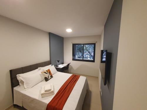 um quarto com uma cama grande e uma janela em 1 quarto, cheio de estilo, condo club Sky com vaga em Curitiba