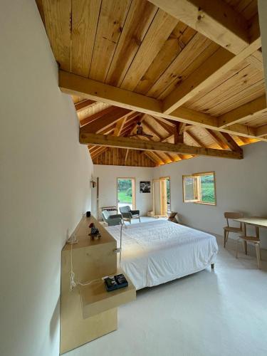 リオ・マイオルにあるArmazém de Sal - Alojamento Loftの広いベッドルーム(ベッド1台、テーブル、椅子付)