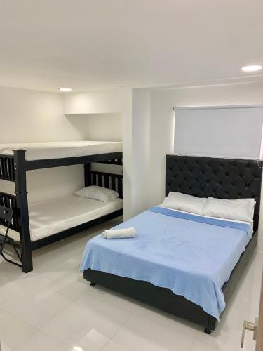 1 dormitorio con 2 literas y 1 cama azul en Casa Nómada - To work and enjoy!, en Santa Marta
