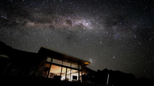 a starry night with a house and the milky way at Origin House Carool in Carool