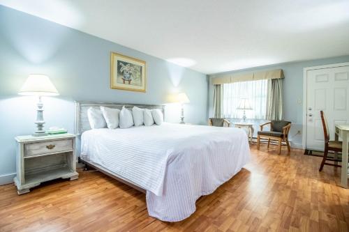 a bedroom with a large white bed and a table at Sea View Motel in Ogunquit