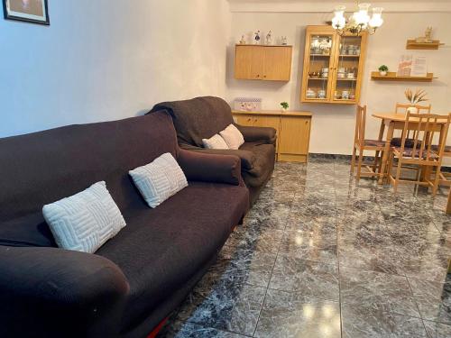 Il comprend un salon avec un canapé brun et une cuisine. dans l'établissement Casa ' A ca Paca ', à Lanjarón