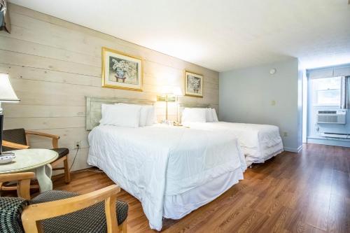 two beds in a room with a table and chairs at Sea View Motel in Ogunquit