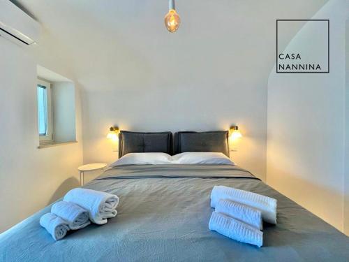 1 dormitorio con 1 cama grande y toallas. en Casa Nannina - Seaview Terrace with Jacuzzi in Capri, en Capri