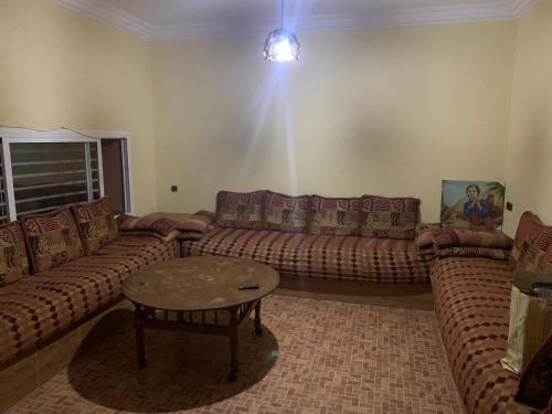 een woonkamer met 2 banken en een salontafel bij Torre del mar in Moulay Bousselham