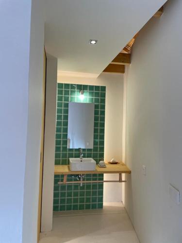 baño con lavabo y pared de azulejos verdes en Armazém de Sal - Alojamento Loft, en Rio Maior