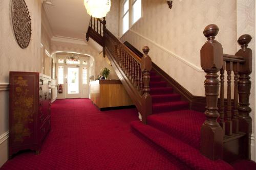 a red carpeted staircase in a building with a red carpet at Denewood Hotel in Bournemouth