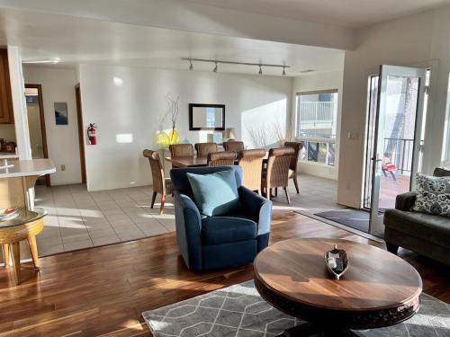 a living room with a blue couch and a table at Oceanfront 2BR Condo, Private Beach & Patio, Rare Find in Carlsbad