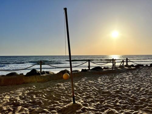 a pole in the sand on a beach with the ocean at Oceanfront 2BR Condo, Private Beach & Patio, Rare Find in Carlsbad