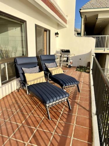 a patio with four chairs and a grill on a balcony at Oceanfront 2BR Condo, Private Beach & Patio, Rare Find in Carlsbad