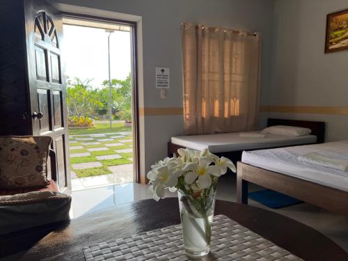 a room with a vase of flowers on a table at La Plumerias in Moalboal