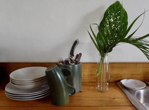 una mesa con platos y un jarrón con una planta en Casa Salvaje Vacation Rentals en Bocas del Toro