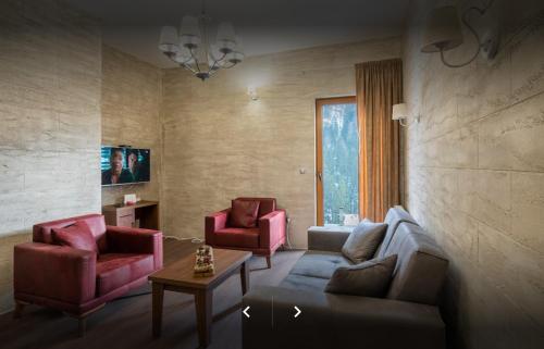 a living room with a couch and two chairs at Keystone Villas in Kolašin