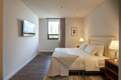 a bedroom with a large bed and two windows at Caluce Apt 2A by Letoh in Chía