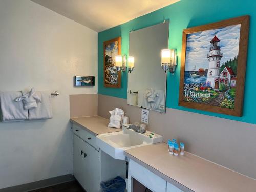 La salle de bains est pourvue d'un lavabo et d'une peinture murale représentant le phare. dans l'établissement Lighthouse Inn, à Florence