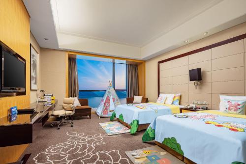 a hotel room with two beds and a flat screen tv at Crowne Plaza Yichang by IHG in Yichang