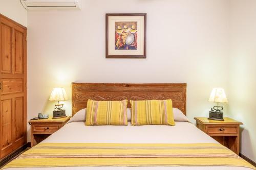 a bedroom with a bed with two night stands and two lamps at Hotel Antigua Miraflores in Lima