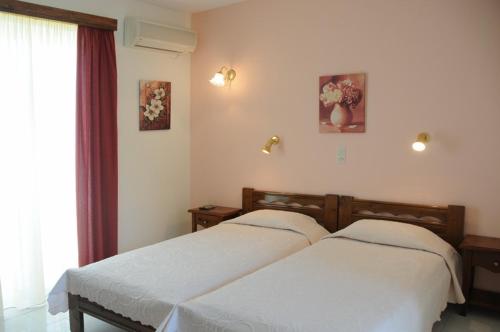 1 dormitorio con 2 camas y ventana en Senia Studios en Agia Marina Aegina