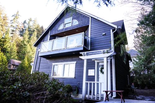 een blauw huis met een witte deur en ramen bij Sea and Cedar Retreat-a home in a tranquil setting in Cowichan Bay