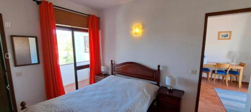 - une chambre avec un lit doté de rideaux rouges et d'un miroir dans l'établissement Seaview Apartment 100m from beach, à Luz