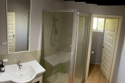 a bathroom with a shower and a sink at Kimberley Cottage in Cable Beach